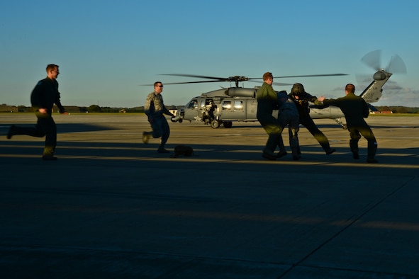 Airmen from the 56th Rescue Squadron tackle Capt. Robert Smith after his fini-flight Nov. 4, 2014, at Royal Air Force Lakenheath, England. It is a tradition to ‘capture’ a pilot after his final flight and paint his feet green to stamp on a ceiling tile.  Smith is the 56th RQS executive officer. (U.S. Air Force photo/Airman 1st Class Erin R. Babis)