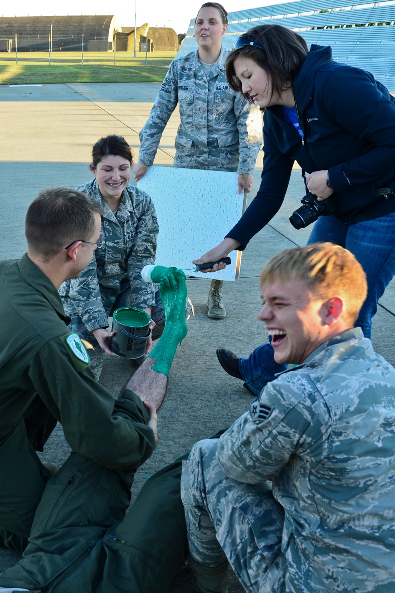 The wife of Capt. Robert Smith paints his feet green after his fini-flight Nov. 4, 2014, at Royal Air Force Lakenheath, England. It is a tradition to “capture” a pilot after his final flight and paint his feet green to stamp on a ceiling tile. Smith is the 56th RQS executive officer. (U.S. Air Force photo/Airman 1st Class Erin R. Babis)