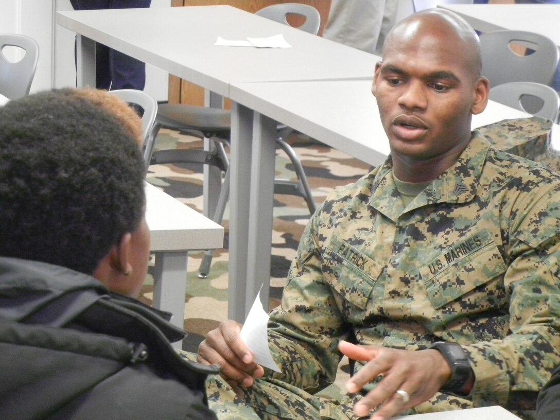 Micah Patrick, financial management resource analyst, Training and Education Command, talks with a teenager during Saturday’s Leadership Mentor Workshop at the National Museum of the Marine Corps. 