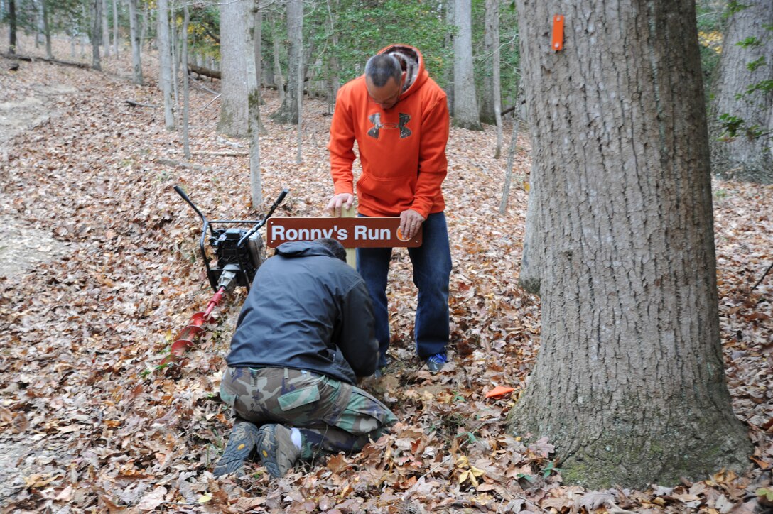 Volunteers Brian Balas and Capt. Thomas Holder install one of the 147 new trail signs aboard Marine Corps Base Quantico on Nov. 13. 