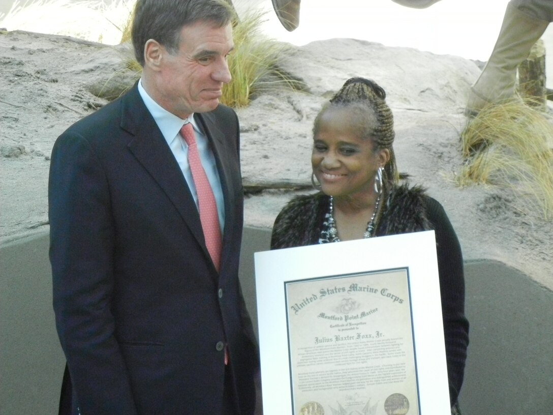 U.S. Sen. Mark Warner (D-Va.) poses with Sheila Foxx and Sharon Foxx, the daughters of the late Cpl. Julius B. Foxx Jr. following Friday’s ceremony at the National Museum of the Marine Corps. Foxx, an original Montford Point Marine, was posthumously awarded the Congressional Gold Medal for his service. His daughters accepted the award on their late father’s behalf.