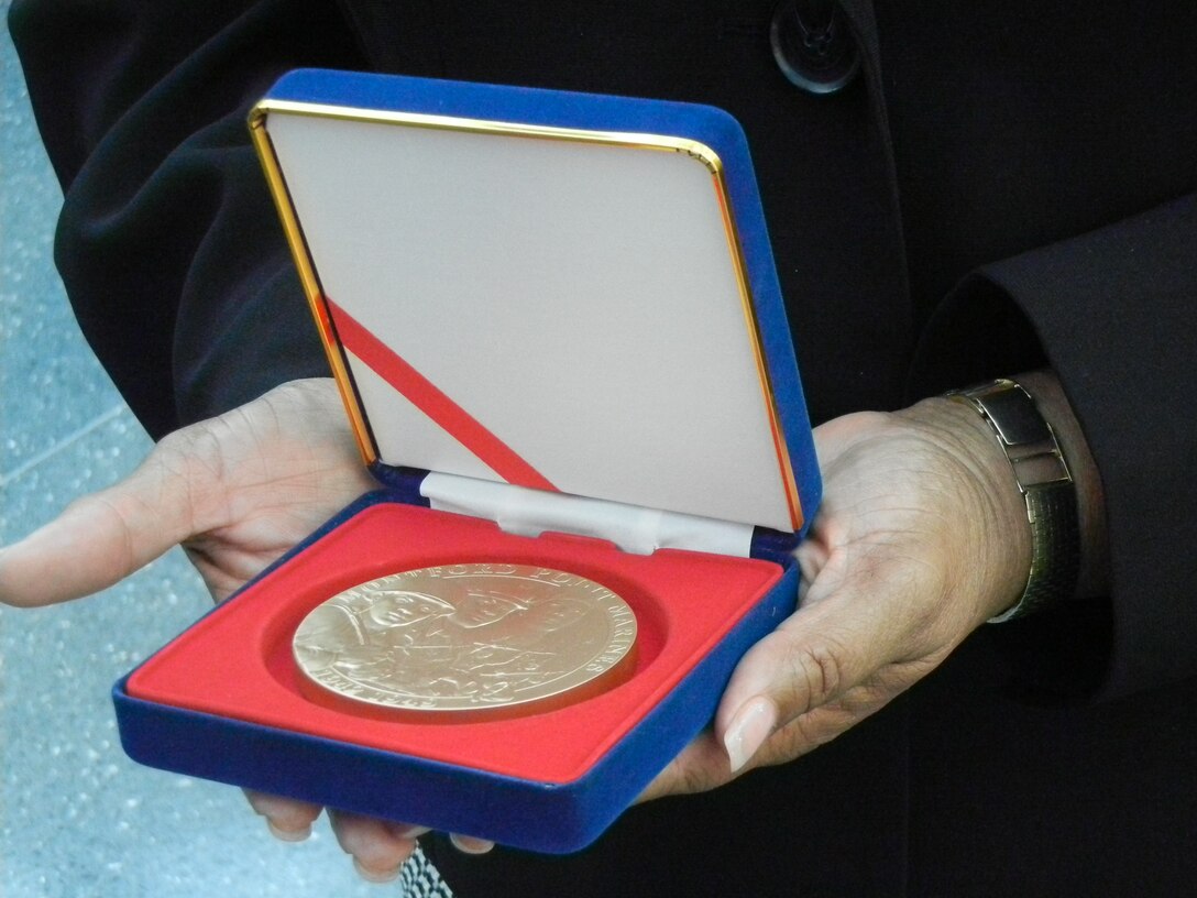 Sheila Foxx and Sharon Foxx, daughters of the late Cpl. Julius B. Foxx Jr. displays the Congressional Gold Medal that was posthumously awarded to her late father during Friday’s ceremony at the National Museum of the Marine Corps. His two daughters accepted the award on behalf of their late father, who was an original Montford Point Marine.