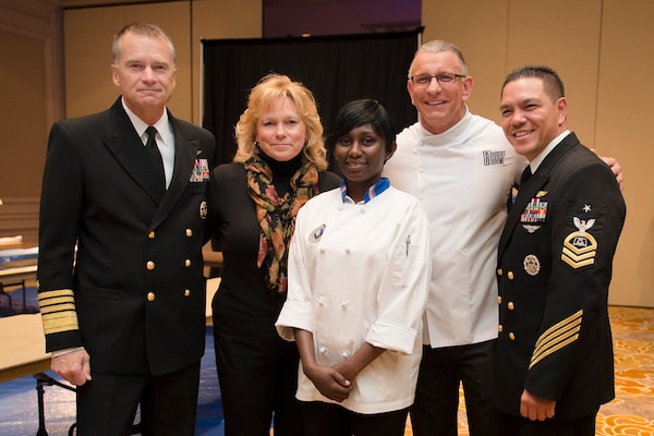 Navy Adm. James A. Winnefeld, Jr., vice chairman of the Joint Chiefs of Staff, his wife, Mary, second left, 2014 USO Military Chef honoree Navy Petty Officer 2nd Class Frida Karani, foreground, celebrity chef Robert Irvine, second right, and 2010 USO Enlisted Aide of the Year Navy Senior Chief Petty Officer Wes Tavares pose for a photo during the annual USO Salute to Military Chefs Dinner at the Ritz-Carlton hotel in Arlington, Va. Nov. 19, 2014.