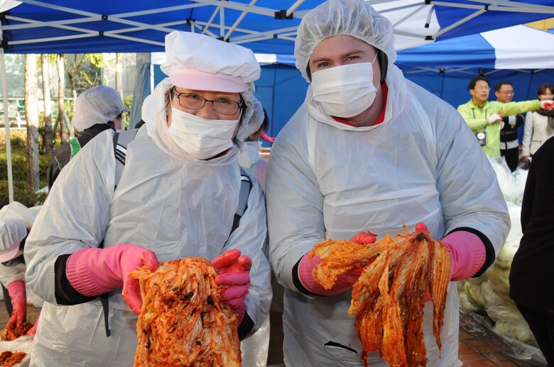 Young Phoenix, from the district's resource management office and Richard Cruikshank, district safety and occupational health specialist, help make kimchi during an annual event to help the needy at the local Jung-gu district office outside the Far East District compound.  