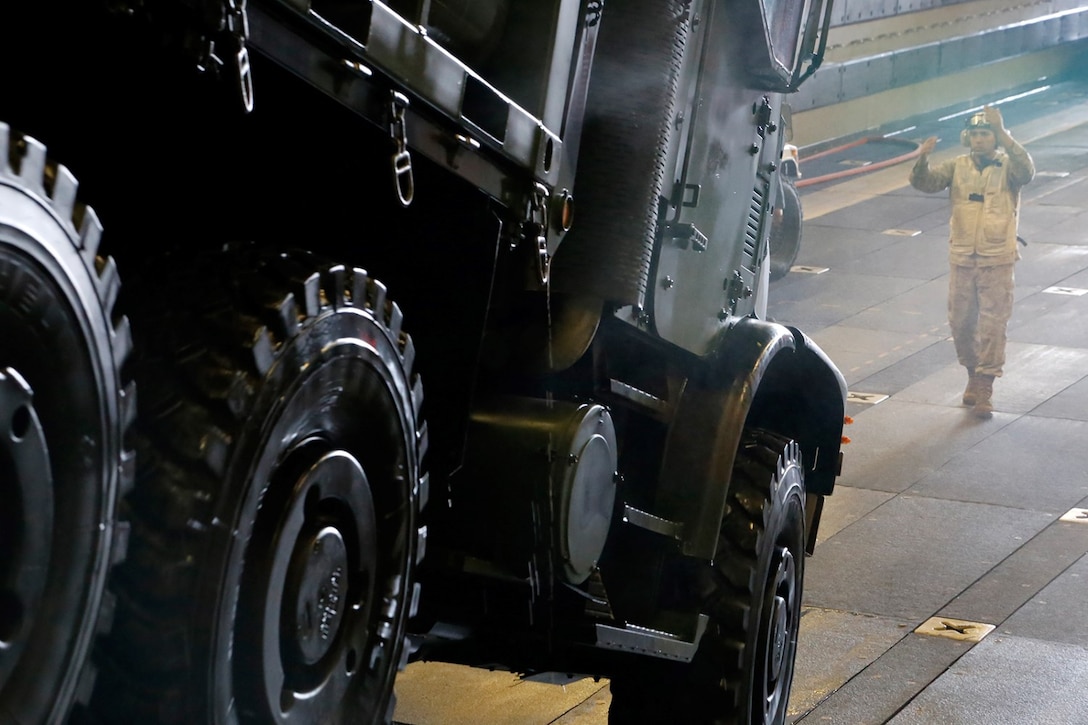 U.S. Marine Corps Gunnery Sgt. Thaddeus M. King, a senior combat cargo assistant with the Combat Cargo department (well deck), amphibious transport dock ship USS San Diego (LPD 22), and native of Phoenix, ground-guides a 7-ton truck during an on-load of equipment and personnel in the well deck of the San Diego, Nov. 16, 2014. The 11th MEU is a forward-deployed, flexible sea-based Marine Air-Ground Task Force embarked with the San Diego as part of the Makin Island Amphibious Ready Group in the U.S. 5th Fleet area of responsibility. (U.S. Marine Corps photos by Gunnery Sgt. Rome M. Lazarus/Released) 