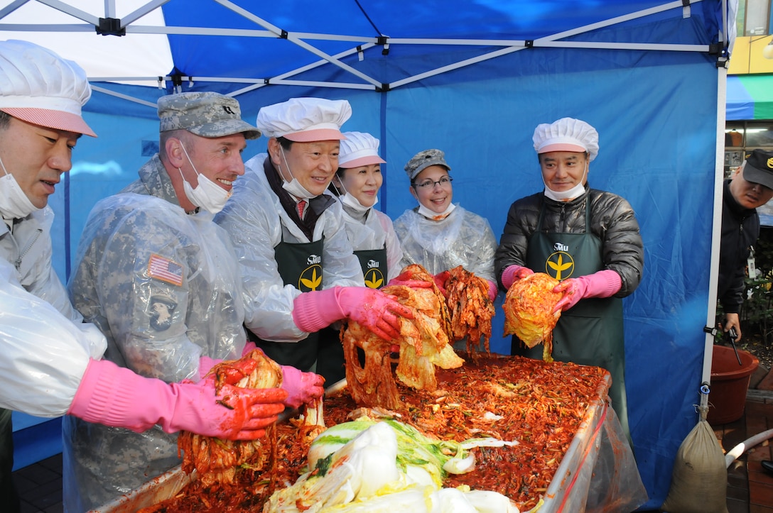 Far East District deputy commander Lt. Col. Julie D’Annunzio (2nd from right) and plans officer Cpt. Lex Oren (2nd from left) join Jung-gu District Mayor Choi Chang-sik (center) and other volunteers at a kimchi making event Nov. 19 outside the Jung-gu district office.