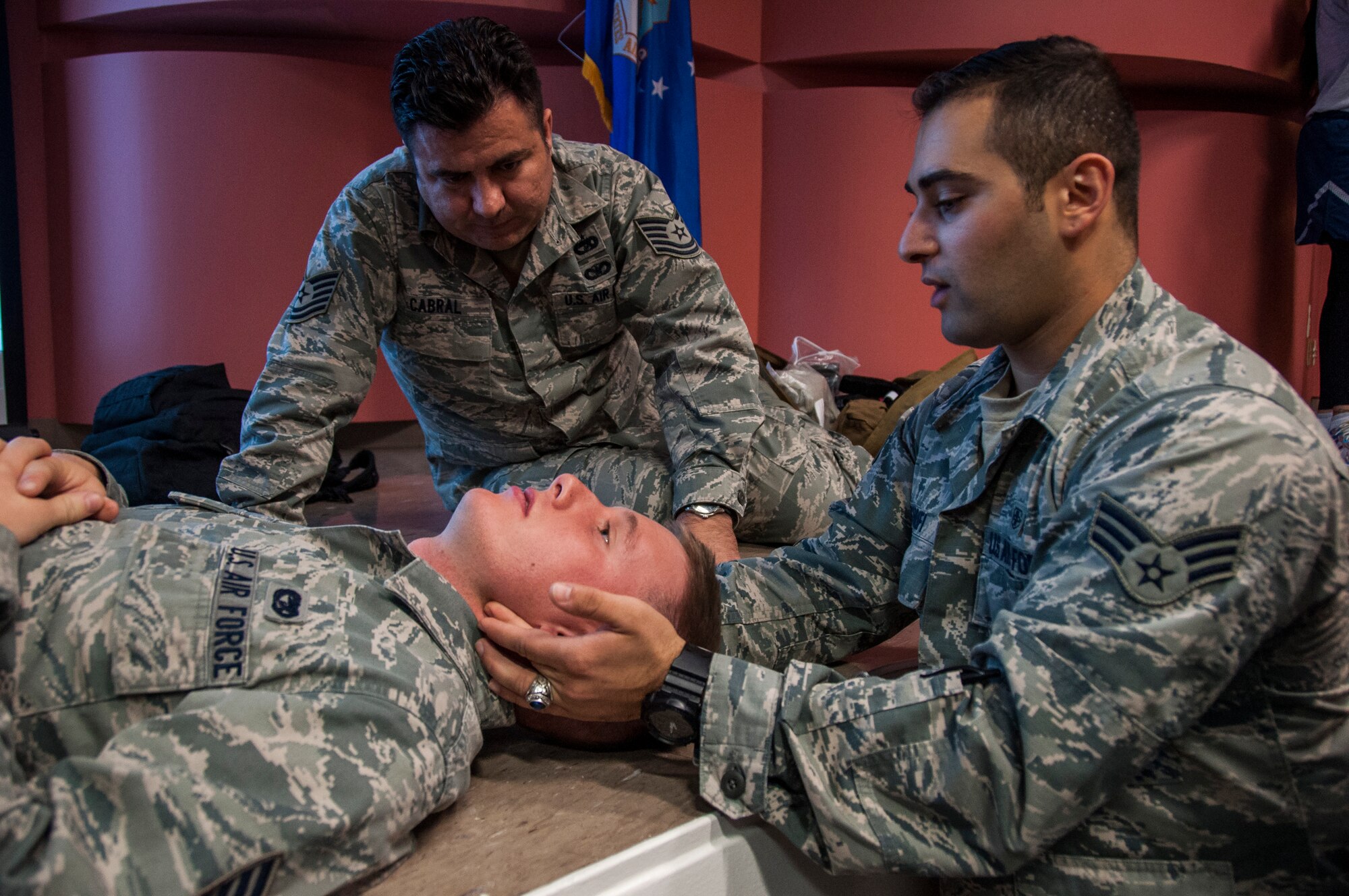 TRAVIS AIR FORCE BASE, Calif. -- Senior Airman Pooian Sharifi, Medical Admin with the 349th Aeromedical Staging Squadron instructs Tech. Sgt. Jeremy Cabral, Passenger Services Craftsman with the 45th Aerial Port Squadron, on how to properly perform the head-tilt chin-lift, jaw-thrust technique and insert the Nasopharyngeal Airway on Staff Sgt. Wilbur Doty, Passenger Services Journeyman, also with the 45th APS, during a hand-on skills training held at the David Grant Medical Center on Nov. 9, 2014. (U.S. Air Force photo / Staff Sgt. Amelia Leonard) 
