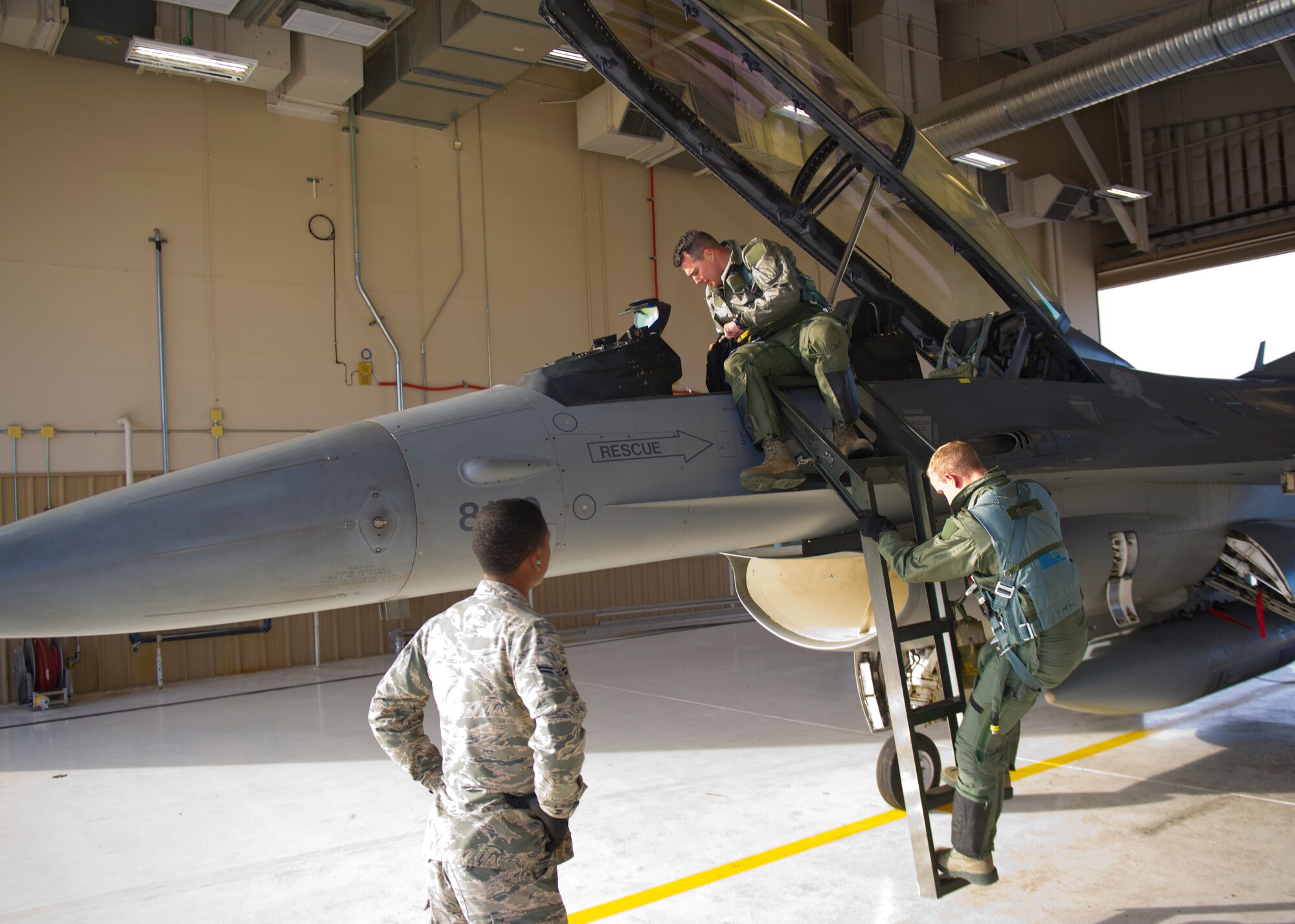 Lt. Col. Jerod Rick, 54th Fighter Group chief of standardization and evaluation, prepares to enter the cockpit on an F-16 Fighting Falcon with 1st Lt. Taylor Roberts, a Basic Course student in the 311th Fighter Squadron, at Holloman Air Force Base, N.M., Nov. 13. Under the new training syllabus for the F-16, all students are prepared for the possibility of flying their first flight alone by training in 8 simulator sorties during their academic phase, including an Emergency Procedures Evaluation from an F-16 Flight Evaluator. (U.S. Air Force photo by Senior Airman Daniel E. F. Liddicoet/Released)
