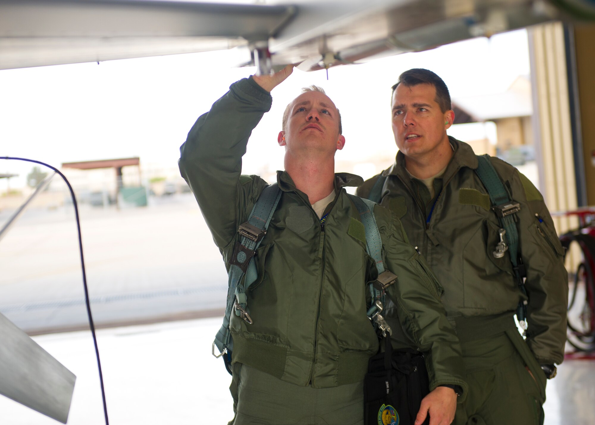 Lt. Col. Jerod Rick, 54th Fighter Group chief of standardization and evaluation, performs a preflight inspection on an F-16 Fighting Falcon with 1st Lt. Taylor Roberts, a Basic Course student in the 311th Fighter Squadron, at Holloman Air Force Base, N.M., Nov. 13. 14 students total were in the first-ever F-16 Basic Course student training program that began Sept. 29, 2014. It is estimated that by June 2015, Holloman will be responsible for 45 percent of F-16 training for the entire Department of Defense. (U.S. Air Force photo by Senior Airman Daniel E. F. Liddicoet/Released)