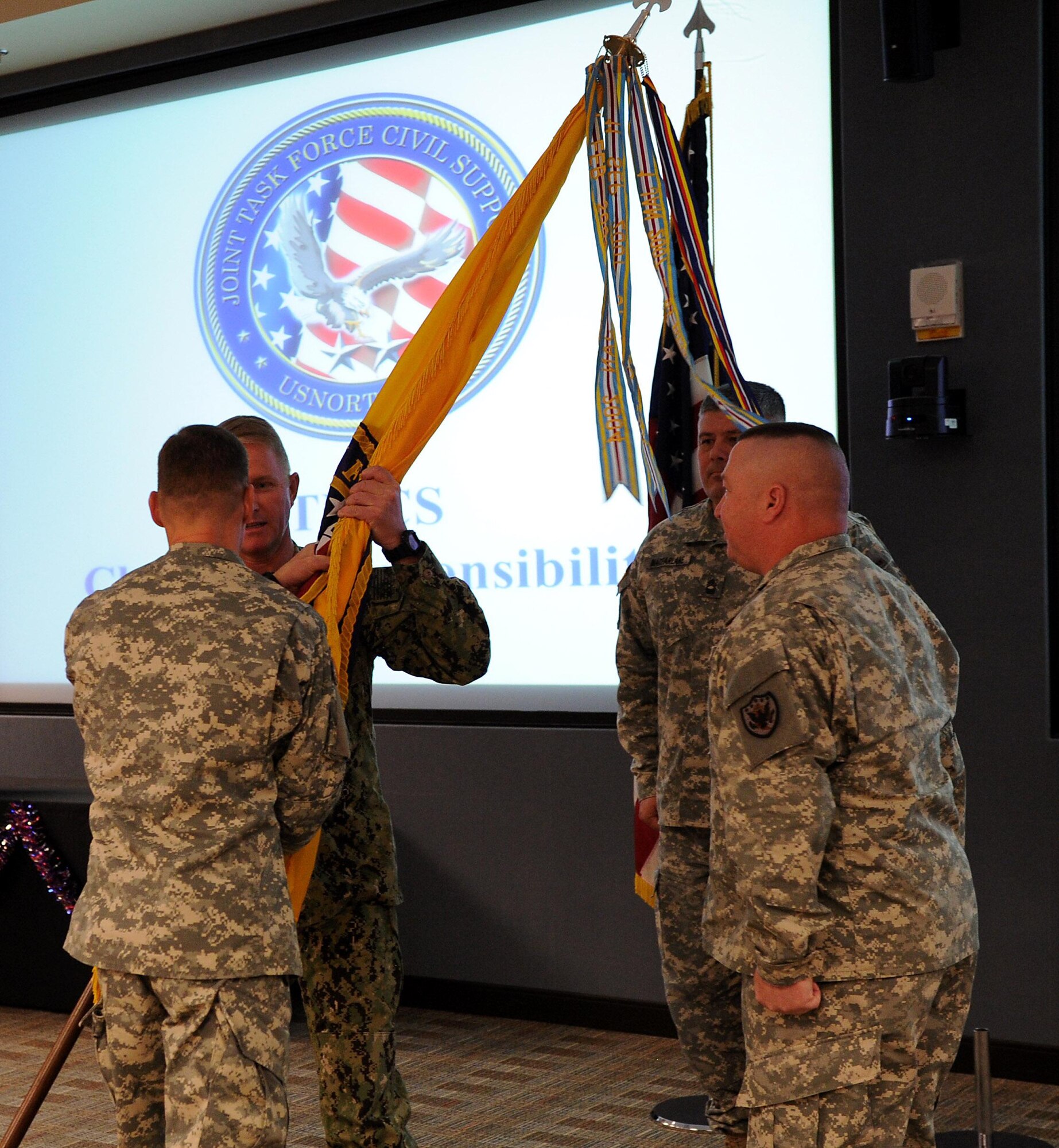 U.S. Navy Command Master Chief Jeffrey Covington, incoming Joint Task Force Civil Support senior enlisted leader, receives the unit colors from U.S. Army Maj. Gen. William Roy, JTF-CS commander, during a change of responsibility ceremony at Fort Eustis, Va., Nov. 14, 2014. The senior enlisted leader of a unit is charged with mentoring enlisted military members, upholding standards, enforcing discipline and giving sound advice to the commander and members of the unit. (Official DOD photo by U.S. Navy Petty Officer 1st Class Brian Dietrick)