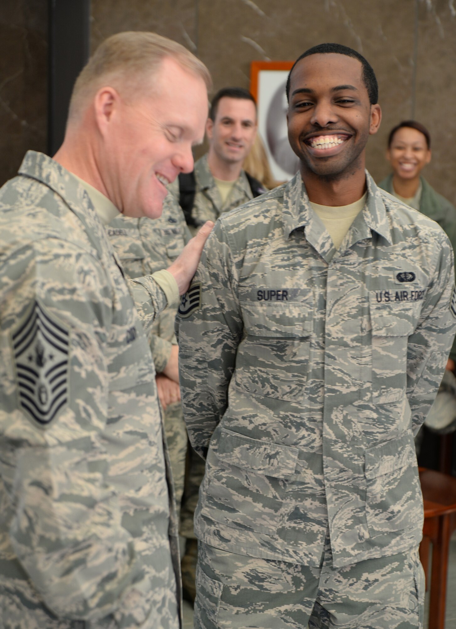 Chief Master Sgt. of the Air Force James A. Cody recognizes Staff Sgt. Mario Super for excellence while at Air Force Mortuary Affairs Operations during his visit to Dover AFB, Del. on Nov. 18, 2014. AFMAO ensures fallen service members receive honor and provide support to families affected. (U.S. Air Force photo/Staff Sgt. John Ayre/Released)