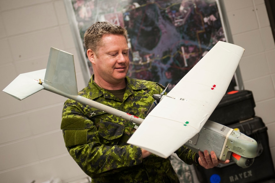 Canadian forces Col. Robert Delaney, Department of National Defence provost marshal, holds an RQ-11B Raven  small unmanned aircraft system during an 820th Base Defense Group tour Nov. 19, 2014, at Moody Air Force Base, Ga. In addition to his position as provost marshal, Delaney also serves as the Canadian forces military police group commander. (U.S. Air Force photo by Airman 1st Class Dillian Bamman/Released)