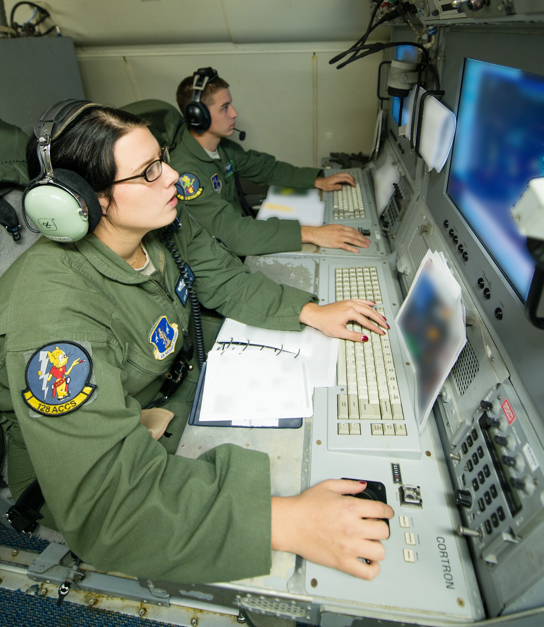 U.S. Air Force Airman 1st Class Caleb Callaway, rear, and Senior Airman Mindy Scott, airborne operations technicians with the 116th Air Control Wing, Georgia Air National Guard, track, analyze and communicate information from their operator work stations during exercise Carolina Thunder, Robins Air Force Base, Ga., Nov. 15, 2014. During the exercise, Airmen and Soldiers from the 116th Air Control Wing and the 138th Military Intelligence Company provided targeting data and intelligence to F-16 Fighting Falcons, AH-64D Apache Attack Helicopters and ground forces using the one-of-a-kind battle management command and control, intelligence, surveillance and reconnaissance capabilities of the E-8C Joint STARS. The exercise was a multi-state, multi-component, collective training exercise conducted during the South Carolina drill weekend. It involved more than 650 participants from South Carolina, North Carolina, Georgia and Tennessee National Guard units. (Portion of photo blurred for security purposes) (U.S. Air National Guard photo by Master Sgt. Roger Parsons/released)