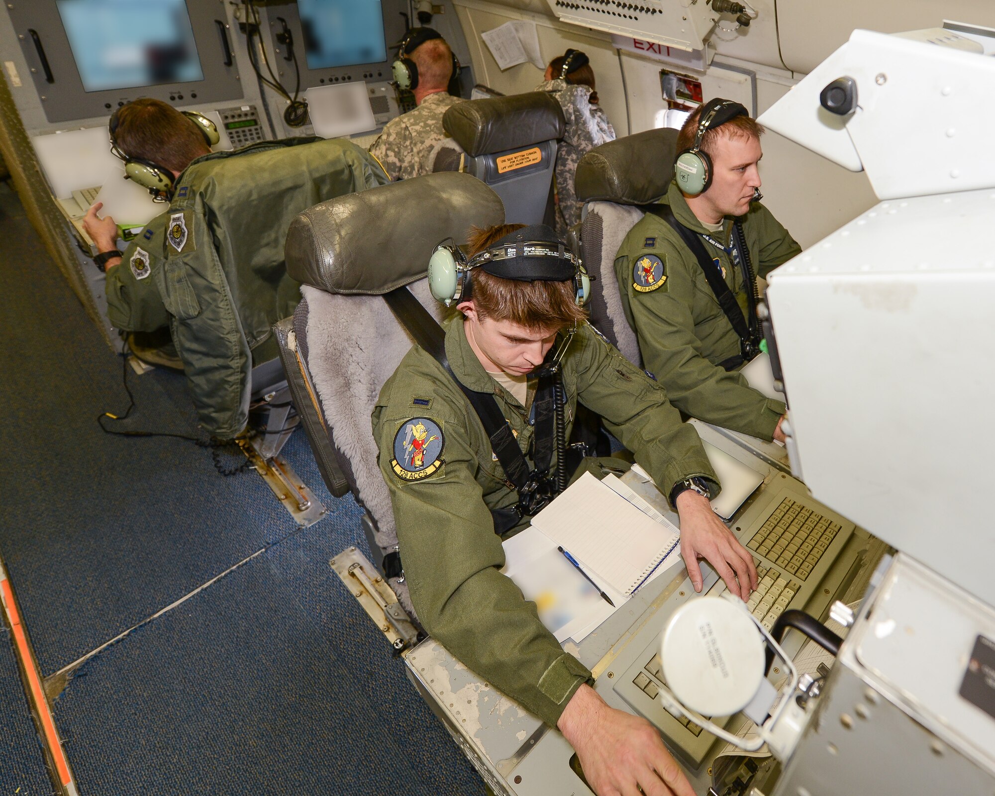Crew members aboard the E-8C Joint STARS aircraft monitor, analyze and communicate information from their operator work stations during exercise Carolina Thunder, Robins Air Force Base, Ga., Nov. 15, 2014. During the exercise, Airmen and Soldiers from the 116th Air Control Wing and the 138th Military Intelligence Company provided targeting data and intelligence to F-16 Fighting Falcons, AH-64D Apache Attack Helicopters and ground forces using the one-of-a-kind battle management command and control, intelligence, surveillance and reconnaissance capabilities of the E-8C Joint STARS. The exercise was a multi-state, multi-component, collective training exercise conducted during the South Carolina drill weekend. It involved more than 650 participants from South Carolina, North Carolina, Georgia and Tennessee National Guard units. (Portion of photo blurred for security purposes) (U.S. Air National Guard photo by Tech. Sgt. Regina Young/released)