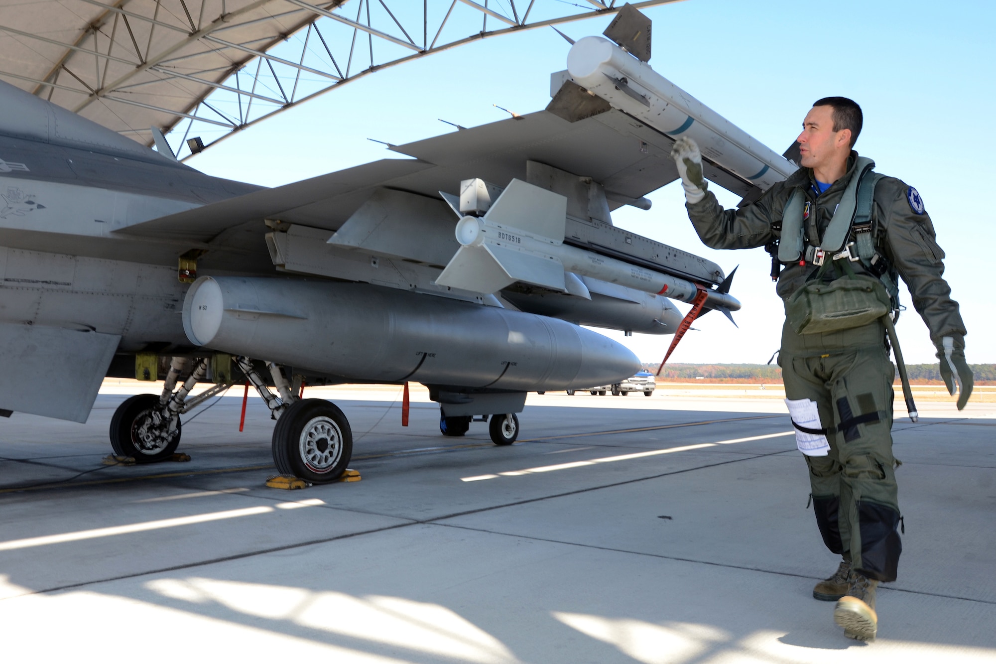 U.S. Air Force Lt. Col. Michael Ferrario, an F-16 fighter pilot with the South Carolina Air National Guard, performs a pre-flight check on the aircraft in preparation for a flight for the joint Army and Air National Guard training exercise called Carolina Thunder. South Carolina National Guard, along with North Carolina and Georgia National Guard units conducted “Carolina Thunder 14”,  a drill weekend, joint training exercise Nov. 15, 2014. More than 30 aircraft participated in the mass take-off from McEntire Joint National Guard Base, Eastover, S.C. Units conducted air and ground operations at the Savannah River Site in Allendale, S.C. The S.C. Air National Guard 169th Fighter Wing’s F-16 Fighting Falcons joined AH-64D Apaches, CH-47 Chinooks, UH-60 Black Hawks and more than 100 Infantry Soldiers from the S.C. Army National Guard to train with Apaches from the N.C. Army National Guard and the Joint Surveillance Target Attack Radar System (JSATRS) and Joint Terminal Training Center (JTAC) from the Georgia Air National Guard in a collective force-on-force, enemy suppression and assault mission. (U.S. Air National Guard photo by Amn Megan Floyd/Released)