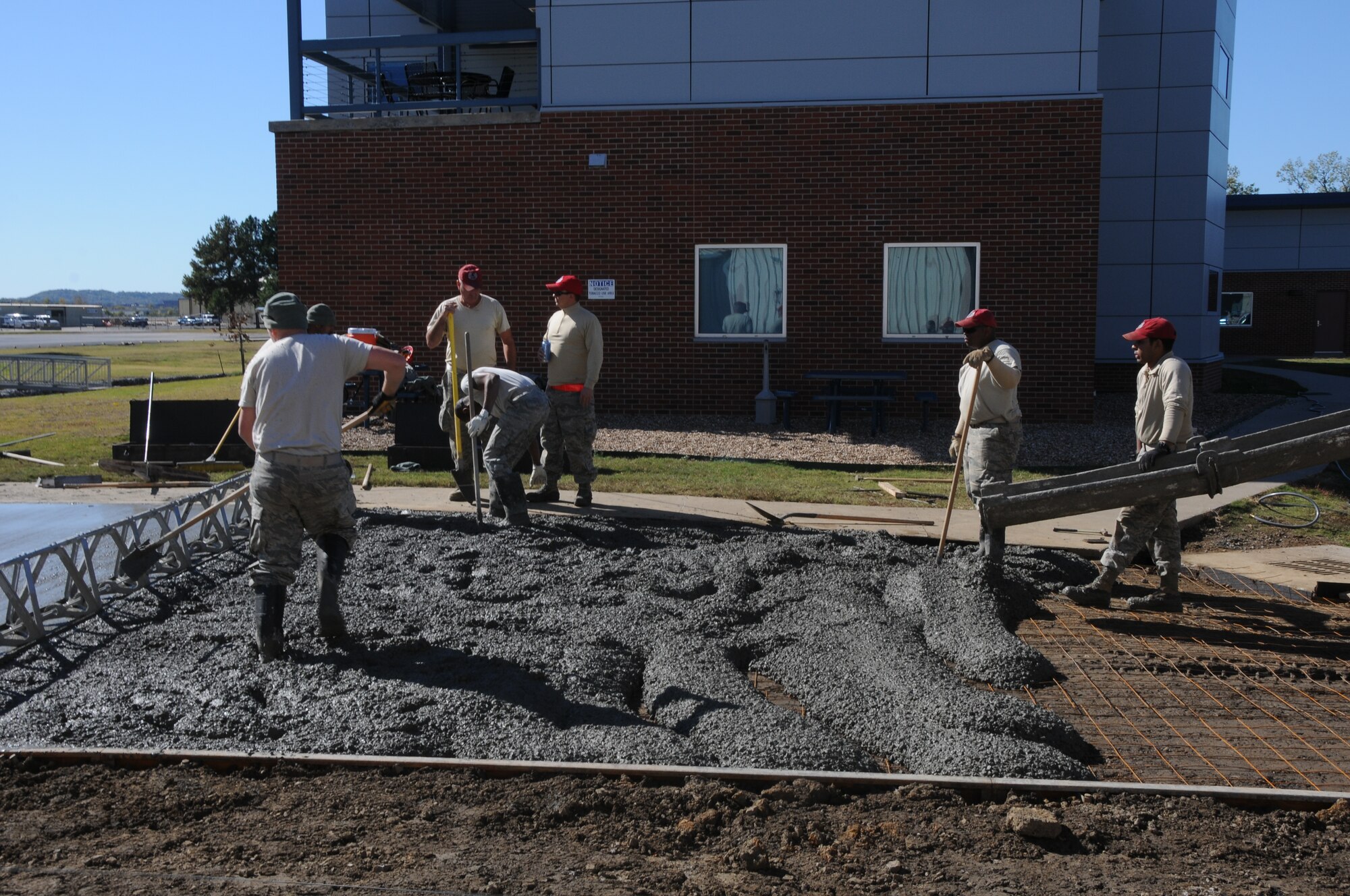 Members of the 567th Rapid Engineers Deployable Heavy Operations Repair Squadron Engineers (RED HORSE) Squadron (RHS) replace a gravel parking area with a concrete parking lot at Ebbing Air National Guard Base, Fort Smith, Ark., Nov. 6, 2014.The 567th RHS ventured to Ebbing Air National Guard Base to retrain  on its RED HORSE capabilities with the 188th Civil Engineering Squadron. The 567th is an Air Force Reserve unit based at Seymour Johnson Air Force Base, N.C. (U.S. Air National Guard photo by Airman 1st Class Cody Martin/Released)