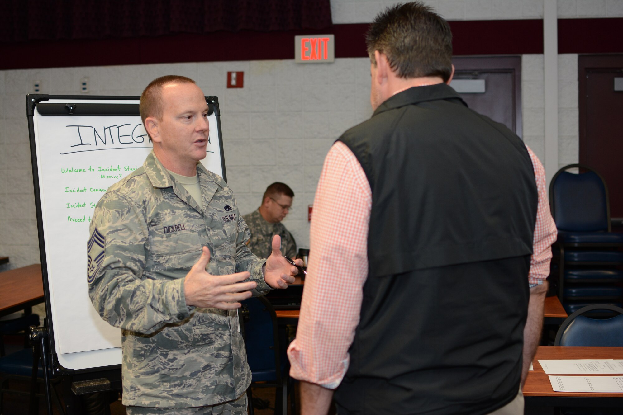 Chief Master Sgt. Alan Dickrell, 115th Fighter Wing force support squadron superintendent, discusses his integration station during the unified reception, staging, onward movement and integration exercise at Volk Field Air National Guard Base, Camp Douglas, Wis., Nov. 19, 2014. The URSOI training and exercise event lasted three days and tested the knowledge and response capabilities of Wisconsin’s civilian and military personnel during emergency situations. (U.S. Air National Guard photo by Senior Airman Andrea F. Rhode)
