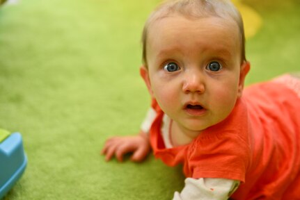 Lindsey Moser, daughter of U.S. Army Sgt. Hans Moser, 7th Transportation Brigade (Expeditionary) wheeled vehicle mechanic, lays on her belly during a Baby and Me Playgroup class at Fort Eustis, Va., Nov. 18, 2014. The class is held every Tuesday during the school year at the Soldier and Family Assistance Center.  (U.S. Air Force photo by Senior Airman Kimberly Nagle/Released)