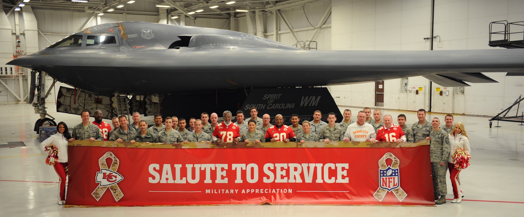 Members of Team Whiteman pose with Kansas City Chiefs cheerleaders and retired players in front of a B-2 Spirit at Whiteman Air Force Base, Mo., Nov. 18, 2014. The Chiefs annual visit is part of their community outreach program. (U.S. Air Force photo by Airman 1st Class Joel Pfiester/Released)

