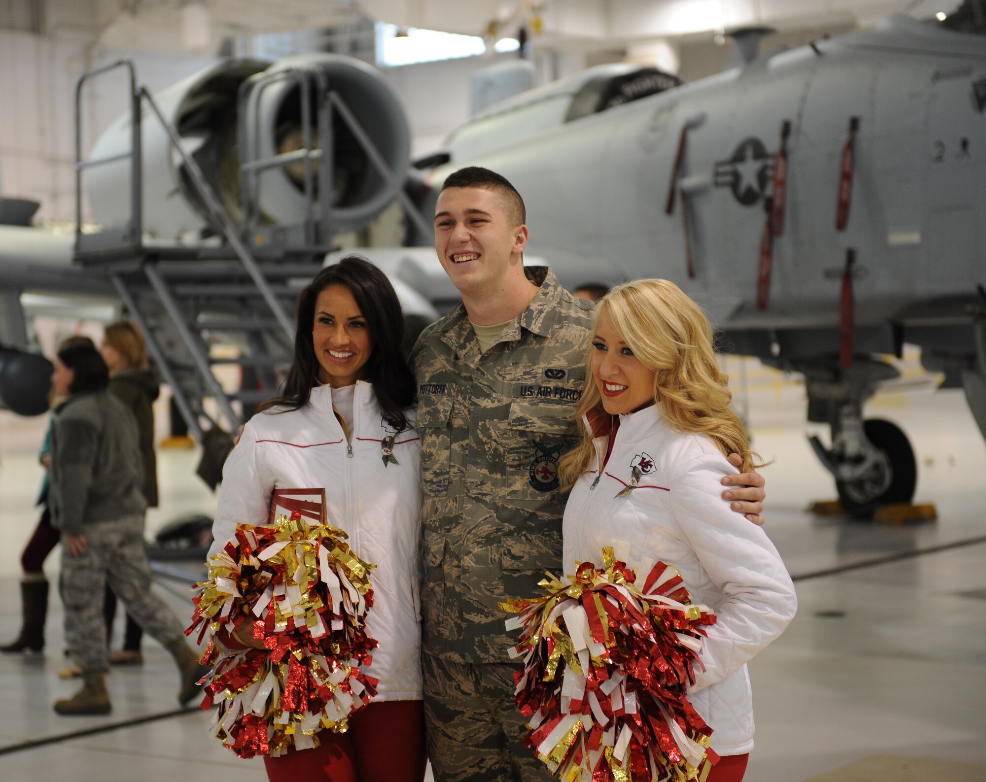 Airman 1st Class Sheldon Pottorff, 509th Civil Engineer Squadron, poses with two Kansas City Chiefs cheerleaders at Whiteman Air Force Base, Mo., Nov. 18, 2014. Visits like these help solidify partnerships between Whiteman Air Force Base and local community organizations. (U.S. Air Force photo by Airman 1st Class Joel Pfiester/Released)
