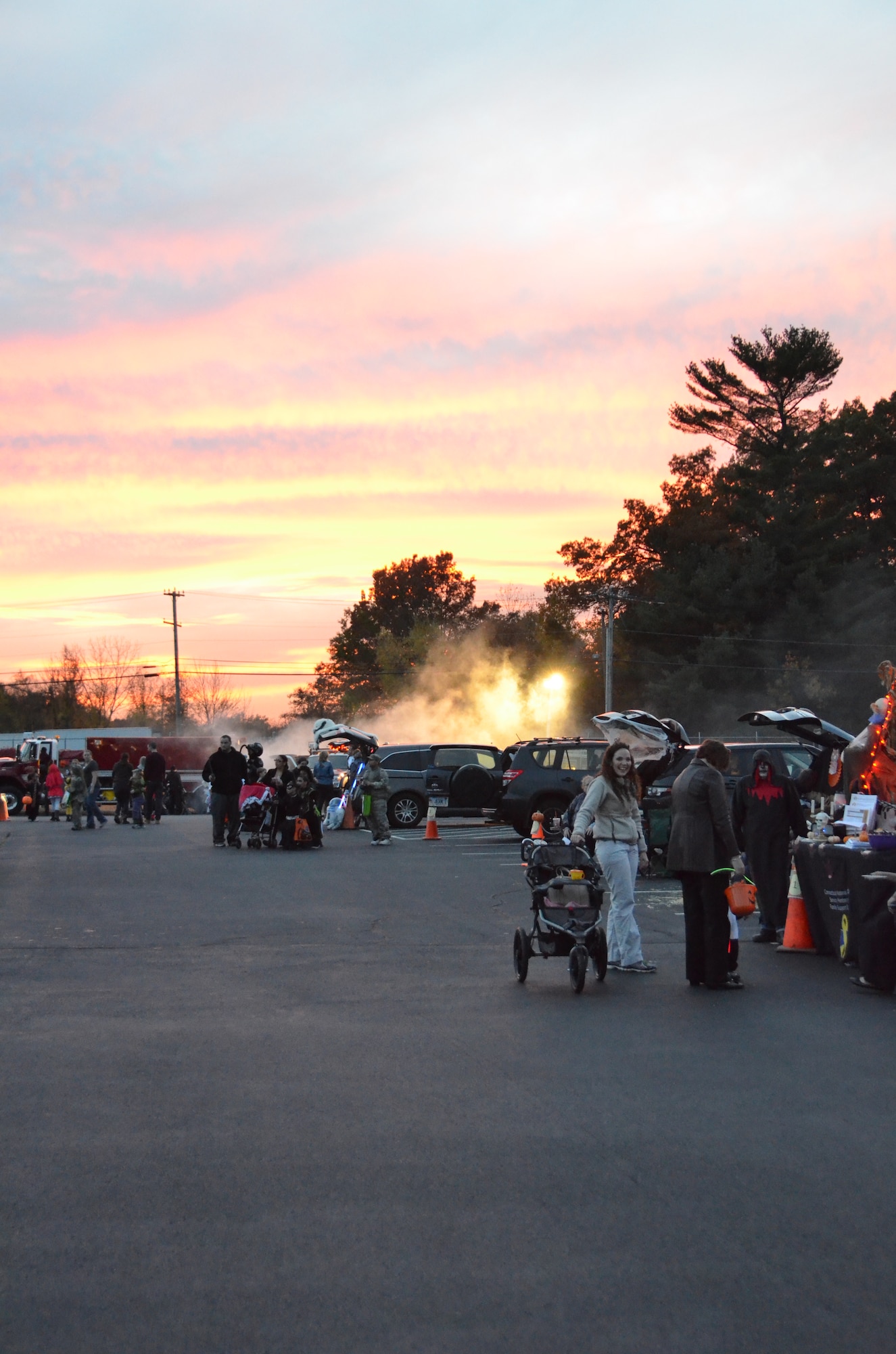 The sun sets as members of the Connecticut National Guard participate in the first annual Trunk or Treat at Bradley Air National Guard Base, East Granby, Conn., Oct. 28, 2014. Walking from car to car, participants are able to trick or treat for candy in a safe environment and enjoy the festive atmosphere offered by the decorated vehicles. (U.S. Air National Guard photo by Tech. Sgt. Joshua Mead) 
