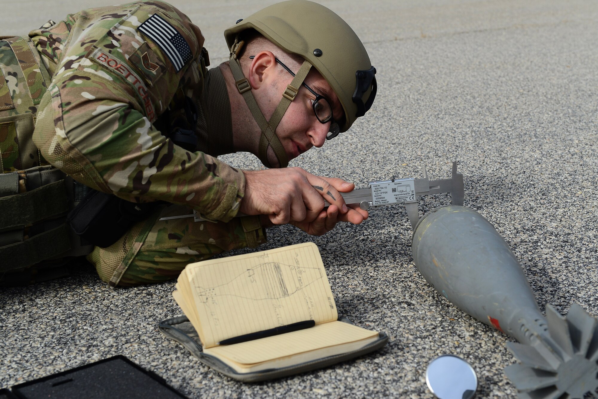 U.S. Air Force Staff Sgt. Chandler Boettcher, 20th Civil Engineer Squadron explosive ordnance disposal technician, measures a simulated unexploded ordnance during Operational Readiness Exercise Weasel Victory 15-01 at Shaw Air Force Base, S.C., Nov. 18, 2014. EOD Airmen measured and photographed the ordnance to ensure proper identification. (U.S. Air Force photo by Airman 1st Class Diana M. Cossaboom/Released)