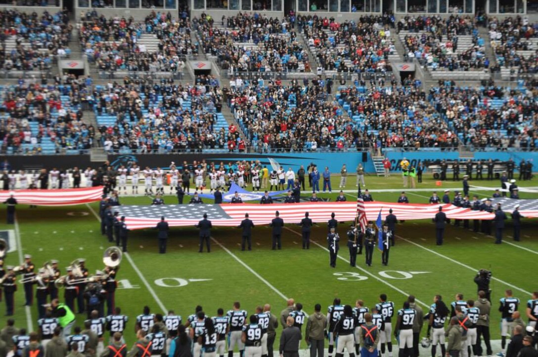 U.S. Air Force Airmen hold a United States flag during the presentation of the colors at the Carolina Panthers Salute to Service game at Bank of America Stadium, Charlotte, N.C., Nov. 16, 2014. The colors were presented by service members from all five branches of the military. (Courtesy photo)