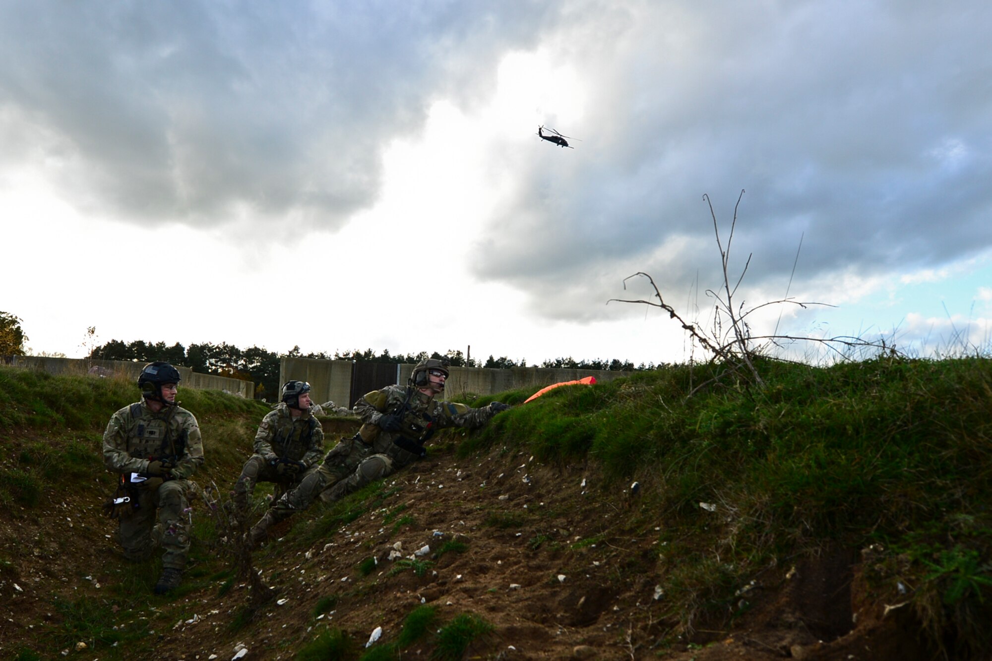 56th Rescue Squadron pararescuemen wait to be picked up by the helicopter during an alternate insertion and extractions training exercise at Royal Air Force Lakenheath, England, Nov. 12, 2014. Pararescuemen train for two years before earning their beret.  (U.S. Air Force photo by Airman 1st Class Erin R. Babis/Released)