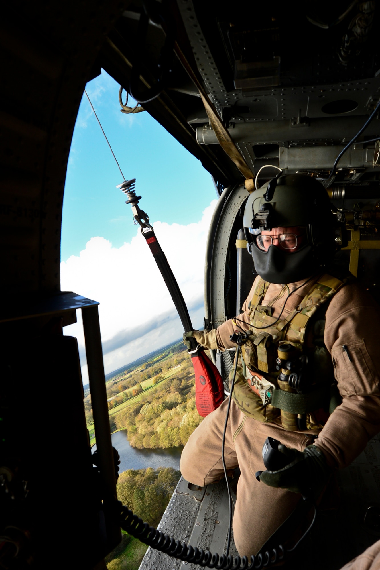 Senior Airman Sven Raemer, 56th Rescue Squadron special mission aviator, holds the hoist used to pull surivors out of areas where a helicopter cannot land during an alternate insertion and extractions training exercise at Royal Air Force Lakenheath, England, Nov. 12, 2014. Traditions of the 56th Rescue Squadron are steeped in history. (U.S. Air Force photo by Airman 1st Class Erin R. Babis/Released)