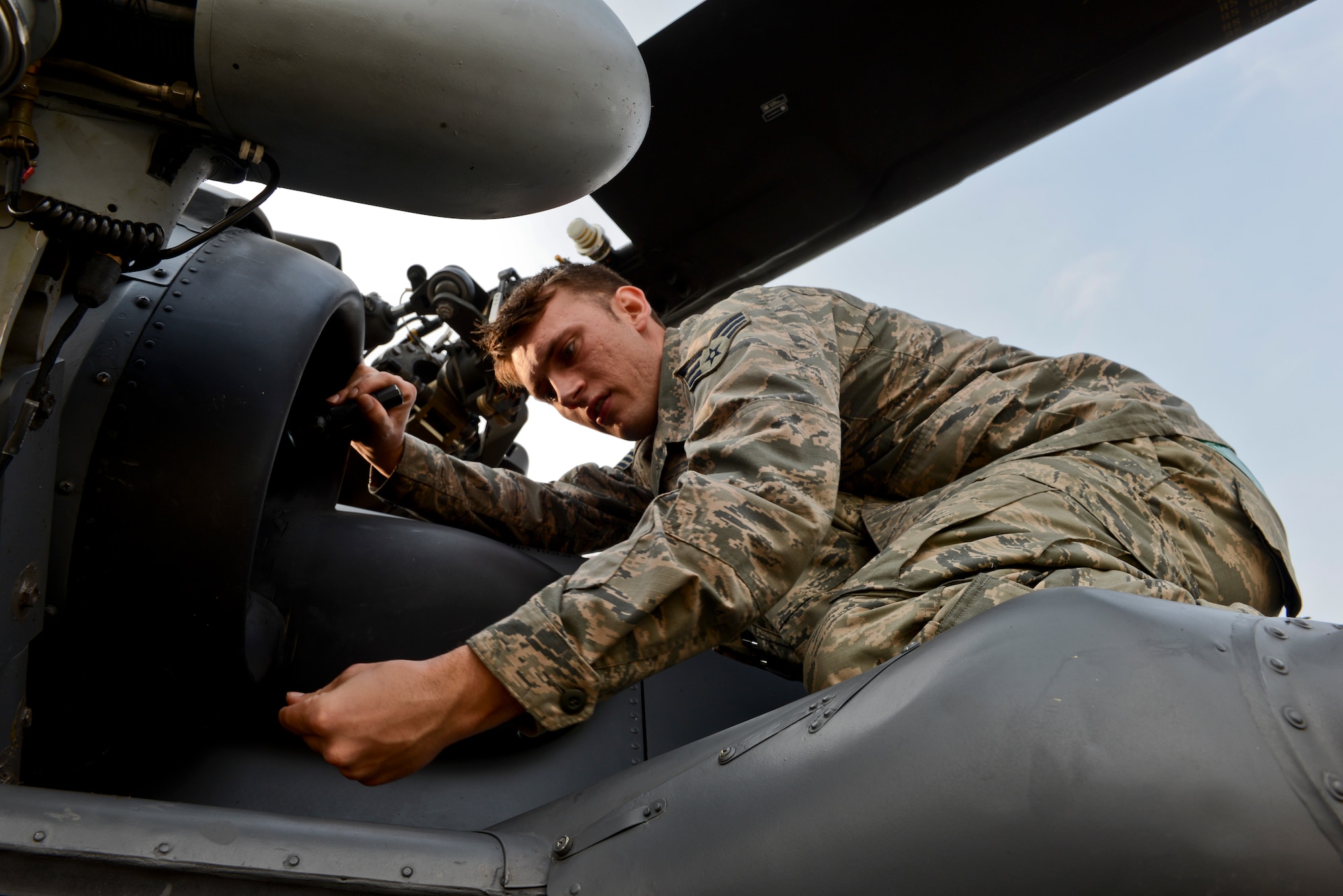 Senior Airman Joshua VanBallegooie, 748th Aircraft Maintenance Squadron, 56th Helicopter Maintenance Unit aerospace propulsion journeyman, performs an engine inlet foreign object debris inspection at Royal Air Force Lakenheath, England, Sept. 22, 2014. At the 56th RQS, the pilots, the maintenance personnel, the air crew, and the pararescuemen are closely integrated. (U.S. Air Force photo by Airman 1st Class Erin R. Babis/Released)