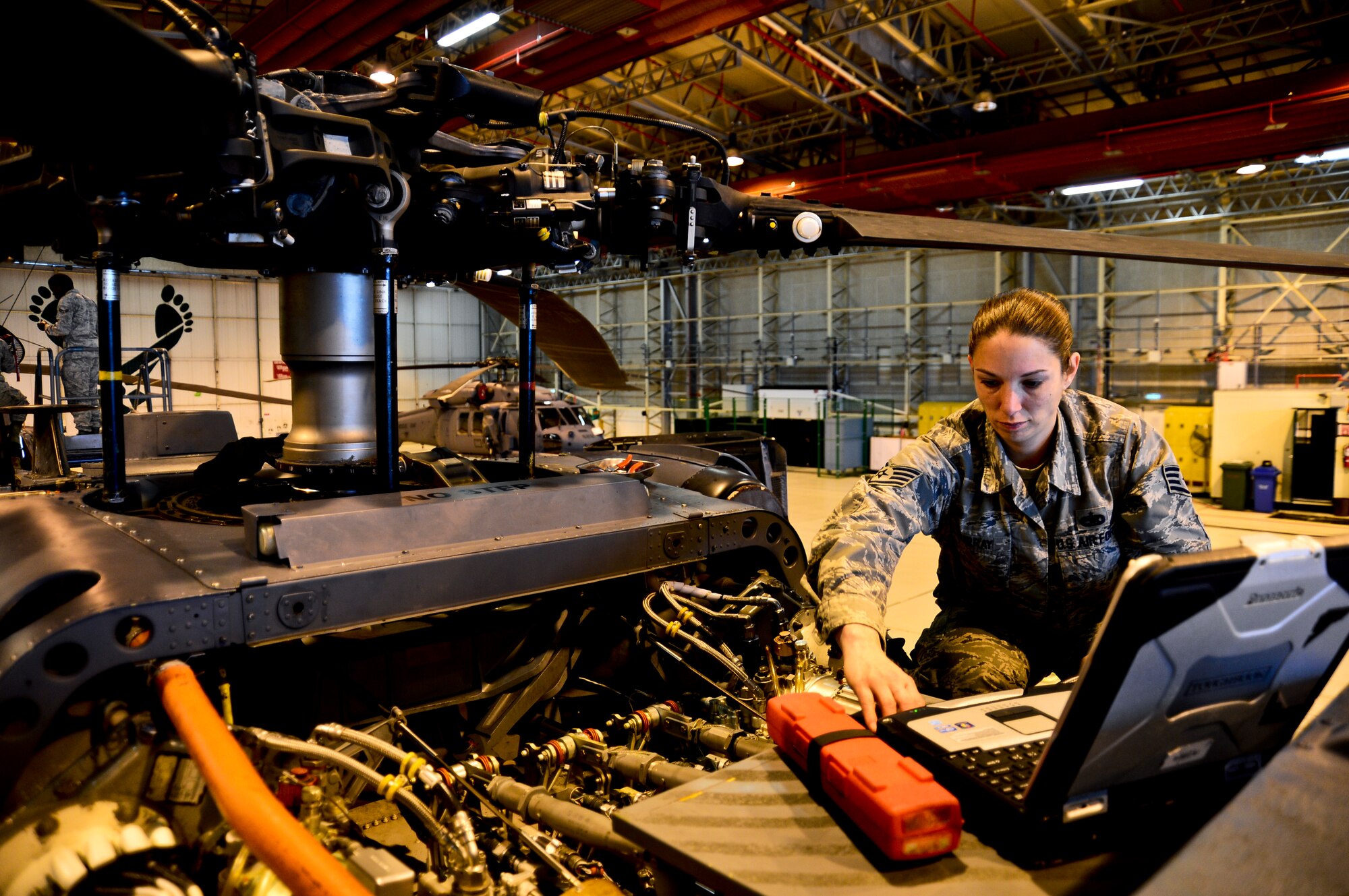 Staff Sgt. Danielle Murray, 56th Helicopter Maintenance Unit HH-60G Pave Hawk propulsion craftsman, reconnects the load demand system on a Pave Hawk at Royal Air Force Lakenheath, England, Oct. 21, 2014. At the 56th RQS, the pilots, the maintenance personnel, the air crew, and the pararescuemen are closely integrated. (U.S. Air Force photo by Airman 1st Class Erin R. Babis/Released)