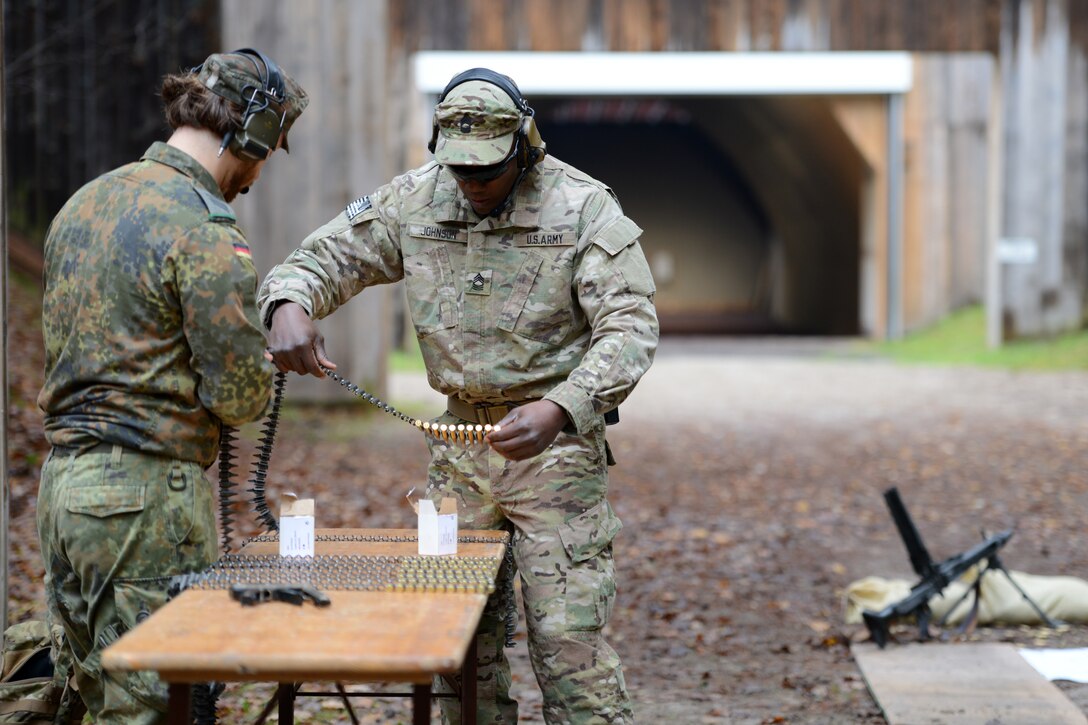 U.S. Army Master Sgt. Sanfa Johnson, right, works with German counterparts to prepare ammunition during the German Armed Forces Badge for Weapons Proficiency on the Panzer Range Complex in Boeblingen, Germany, Nov. 19, 2014. Johnson is assigned to Special Operations Command Europe. 