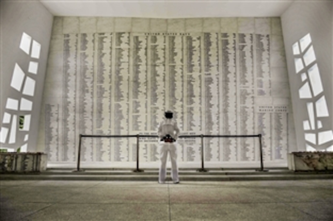 Navy Petty Officer 2nd Class Jennifer Usenick reads the list of fallen military members at the USS Arizona Memorial in Pearl Harbor, Hawaii, Nov. 7, 2014. The memorial marks the resting place of more than 1,000 sailors and Marines who were killed aboard the battleship USS Arizona during the attack on Pearl Harbor. 