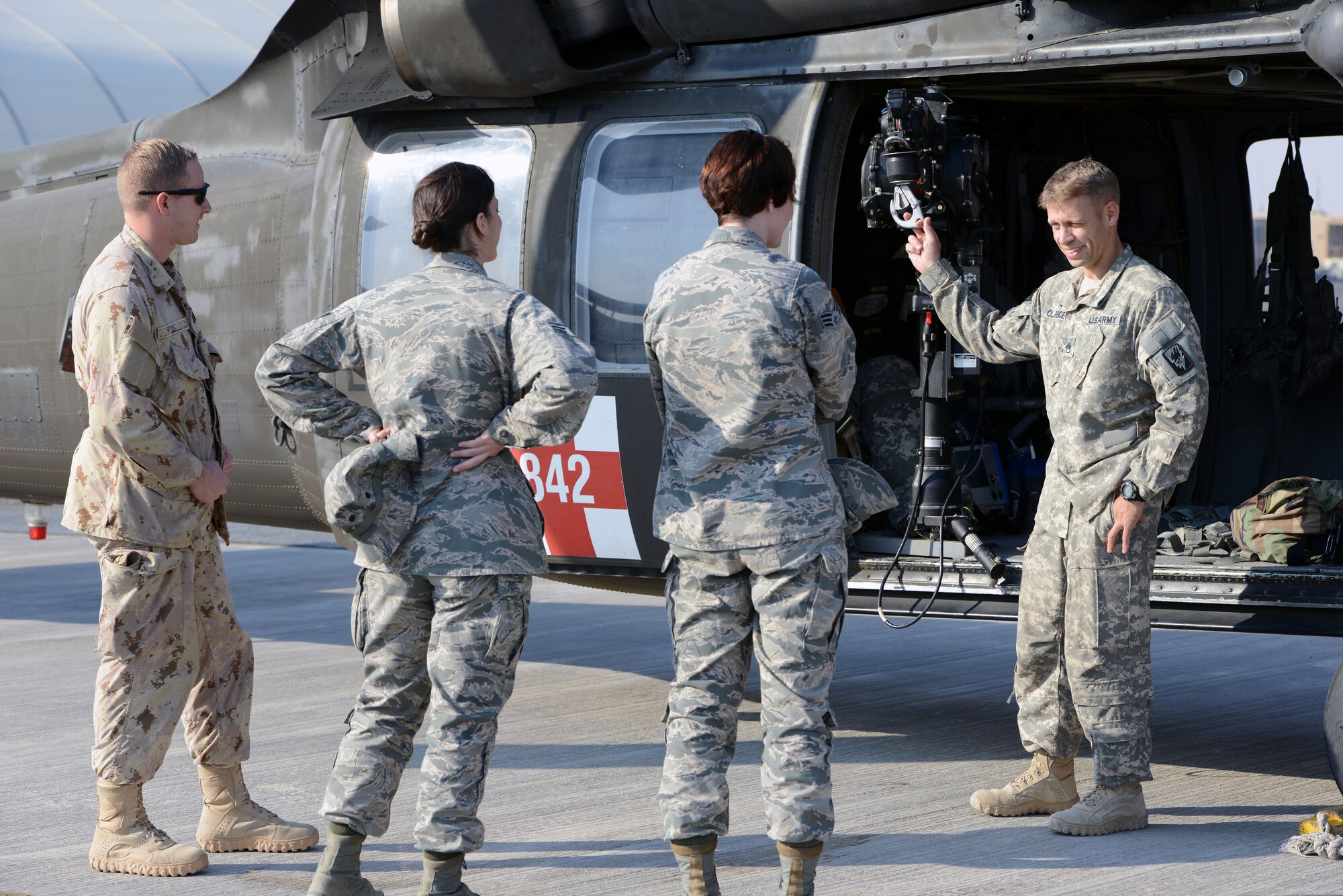Army Staff Sgt. David Clarence, 1st Battalion, 126th Aviation Regiment, explains the equipment on a UH-60 BlackHawk helicopter during medical evacuation training Nov. 14, 2014. Airmen from the 386th Expeditionary Medical Group and Italian and Canadian air forces received the training Nov. 14 and 16. (U.S. Air Force photo by Tech. Sgt. Jared Marquis/released)
