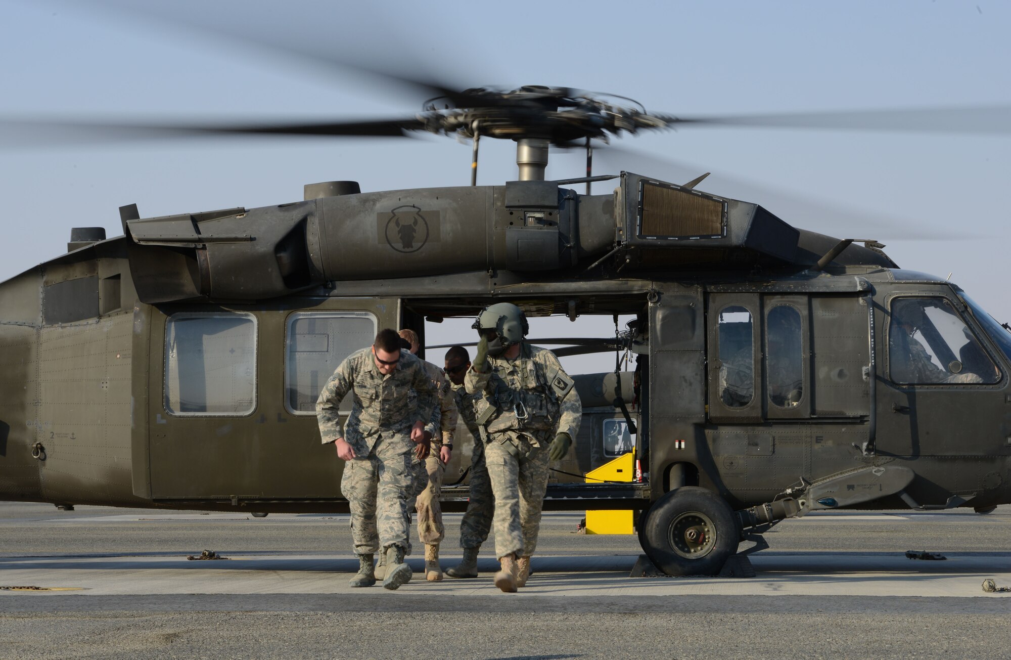 Airmen from the 386th Expeditionary Medical group return from a UH-60 BlackHawk helicopter after loading a patient during medical evacuation training Nov. 14, 2014. Airmen from the 386th EMDG and Italian and Canadian air forces received the training Nov. 14 and 16. (U.S. Air Force photo by Tech. Sgt. Jared Marquis/released)