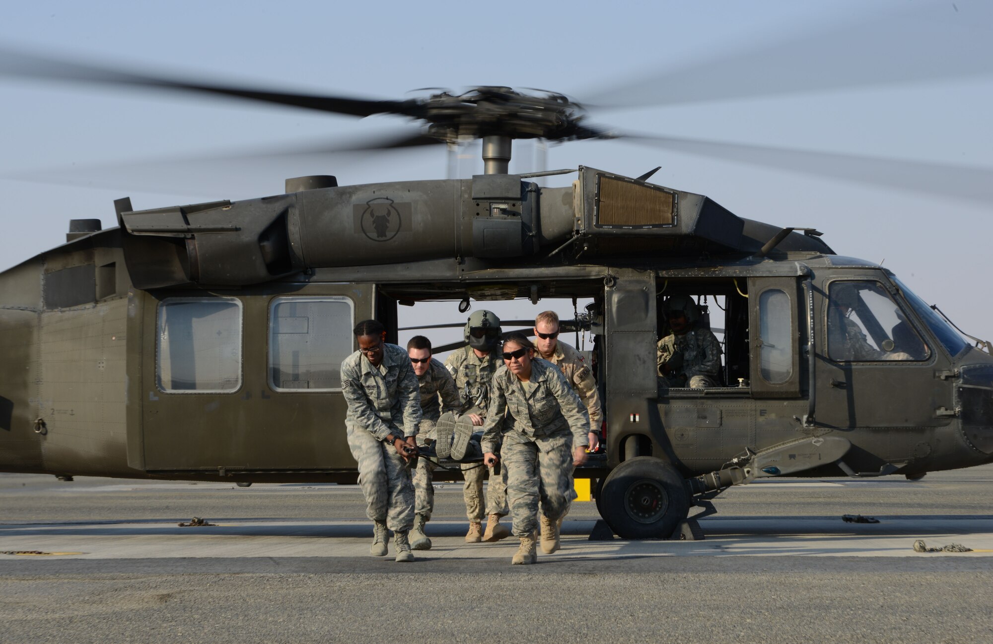 Airmen from the 386th Expeditionary Medical group offload a patient from a UH-60 BlackHawk helicopter during medical evacuation training Nov. 14, 2014. Airmen from the 386th EMDG and Italian and Canadian air forces received the training Nov. 14 and 16. (U.S. Air Force photo by Tech. Sgt. Jared Marquis/released)