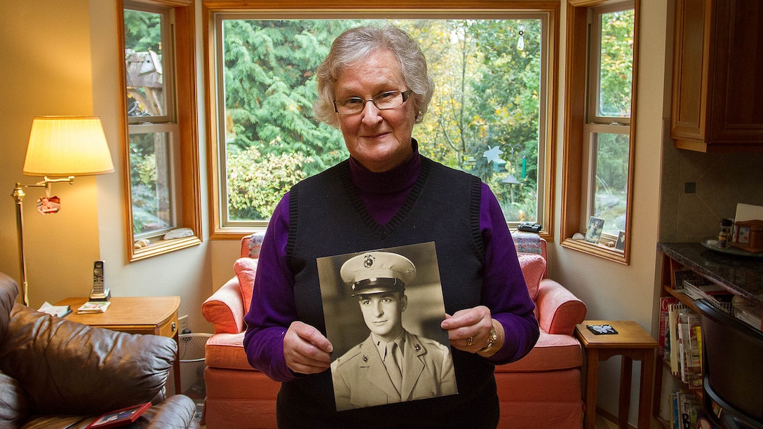 Barbara Kenney displays a photo of her late father, U.S. Marine 1st Lt. George Greeley Wells, at her home in Bellevue, Washington, Oct. 25, 2014. Greeley served as the adjutant of 2nd Battalion, 28th Marine Regiment, 5th Marine Division, during World War II’s famed Battle of Iwo Jima. He carried the first flag that was raised on Mt. Suribachi, a moment later captured by Associated Press photographer Joe Rosenthal in the war’s most famous photo. In the 1990s and early 2000s, he was featured in James Bradley’s best-selling book “Flags of Our Fathers” and “War Stories with Oliver North,” produced by the retired Marine and Fox News correspondent. Greeley, a native of Lake Forest, Illinois, moved with his family from Harding Township, New Jersey, to Bellevue in the early 2000s. At 94, he passed away in his sleep here Sept. 22, 2014. 