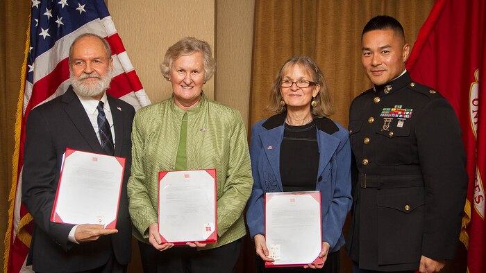 Greeley Wells Jr., Barbara Kenney and Elizabeth Wells display letters and challenge coins they received from Maj. Sung Kim, the commanding officer of Marine Corps Recruiting Station Seattle, on behalf of 35th Commandant of the Marine Corps Gen. James Amos following a memorial service for their father, 1st Lt. George Greeley Wells, in Bellevue, Washington, Oct. 25, 2014. Greeley served as the adjutant of 2nd Battalion, 28th Marine Regiment, 5th Marine Division, during World War II’s famed Battle of Iwo Jima. He carried the first flag that was raised on Mt. Suribachi, a moment later captured by Associated Press photographer Joe Rosenthal in the war’s most famous photo. In the 1990s and early 2000s, he was featured in James Bradley’s best-selling book “Flags of Our Fathers” and “War Stories with Oliver North,” produced by the retired Marine and Fox News correspondent. Greeley, a native of Lake Forest, Illinois, moved with his family from Harding Township, New Jersey, to Bellevue in the early 2000s. At 94, he passed away in his sleep here Sept. 22, 2014. 