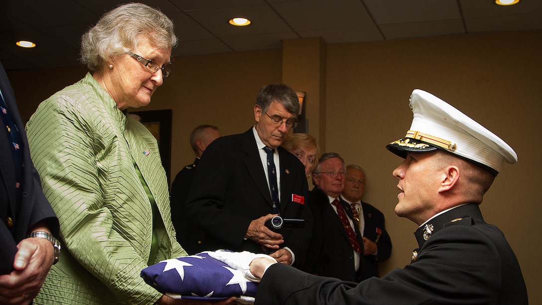 Maj. Stephen Harding, a supply officer with Combat Logistics Battalion 23, presents a flag on behalf of 35th Commandant of the Marine Corps Gen. James Amos to Barbara Kenney during a memorial service for her father, 1st Lt. George Greeley Wells, in Bellevue, Wash., Oct. 25, 2014. Greeley served as the adjutant of 2nd Battalion, 28th Marine Regiment, 5th Marine Division, during World War II’s famed Battle of Iwo Jima. He carried the first flag that was raised on Mt. Suribachi, a moment later captured by Associated Press photographer Joe Rosenthal in the war’s most famous photo. In the 1990s and early 2000s, he was featuring in James Bradley’s best-selling book “Flags of Our Fathers” and “War Stories with Oliver North,” produced by the retired Marine and Fox News correspondent. Greeley, a native of Lake Forest, Ill., moved with his family from Harding Township, N.J., to Bellevue in the early 2000s. At 94, he passed away in his sleep here Sept. 22, 2014. 