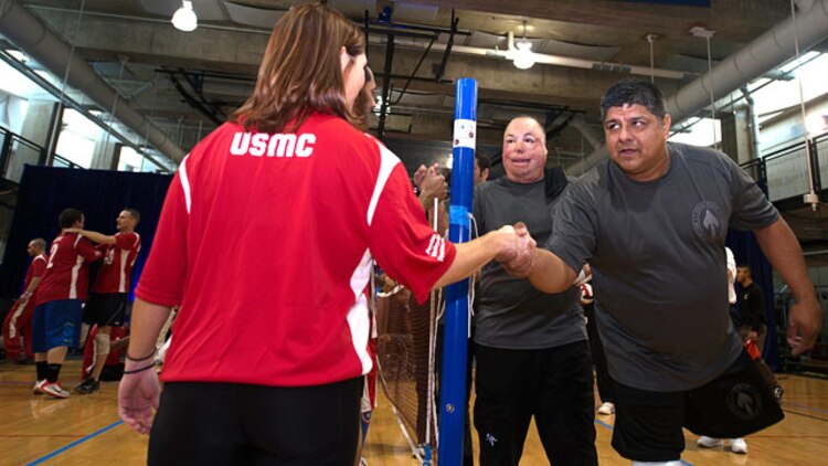 A member of the Marine Corps Sitting Volleyball team shakes hands with a member of the Special Operations Command Sitting Volleyball team after a match during the 4th Annual Joint Services Sitting Volleyball Tournament in the Pentagon, Arlington, Va. on Nov. 20, 2014.  The Marine Corps team took home the trophy winning the second match 25 to 23. The tournament was just one of many activities, which took place throughout the month. Every November since 2008, the Department of Defense and each branch of the armed forces promotes wounded warrior programs, activities and personal feats of recovery through Warrior Care Month. 