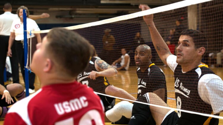 Members of the Army sitting volleyball team prepare to block the ball in a match against Marines during the 4th Annual Joint Services Sitting Volleyball Tournament at the Pentagon, Arlington, Va on Nov. 20, 2014. Every November since 2008, the Department of Defense and each branch of the armed forces promotes wounded warrior programs, activities and personal feats of recovery through Warrior Care Month. 