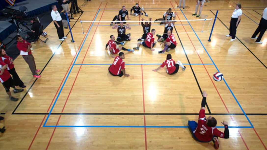 The Marine Corps sitting volleyball team and the Army sitting volleyball team begin a match during the 4th Annual Joint Services Sitting Volleyball Tournament at the Pentagon, Arlington, Va on Nov. 20, 2014.  The Marine Corps team took home the trophy winning the second match 25 to 23. Every November since 2008, the Department of Defense and each branch of the armed forces promotes wounded warrior programs, activities and personal feats of recovery through Warrior Care Month. 