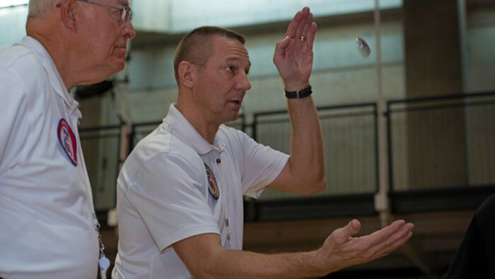 Referees for the 4th Annual Joint Services Sitting Volleyball Tournament toss a coin to determine which team will serve at the Pentagon, Arlington, Va. on Nov. 20, 2014. Every November since 2008, the Department of Defense and each branch of the armed forces promotes wounded warrior programs, activities and personal feats of recovery through Warrior Care Month. 