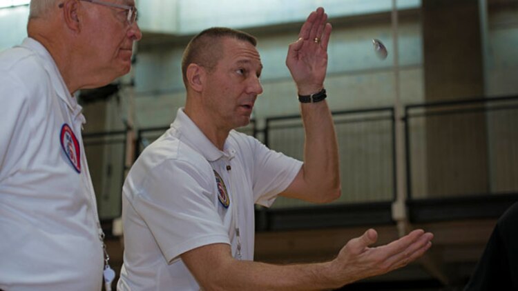 Referees for the 4th Annual Joint Services Sitting Volleyball Tournament toss a coin to determine which team will serve at the Pentagon, Arlington, Va. on Nov. 20, 2014. Every November since 2008, the Department of Defense and each branch of the armed forces promotes wounded warrior programs, activities and personal feats of recovery through Warrior Care Month. 