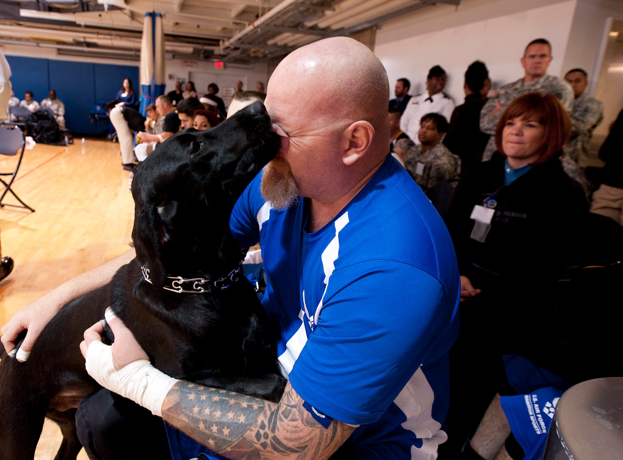 Retired Tech. Sgt. Keith Sekora receives a kiss from his dog, Pintler, during the 4th Annual Pentagon Sitting Volleyball Tournament Nov. 20, 2014, at the Pentagon Athletic Club.  In conjunction with Warrior Care Month, wounded warriors from each service's warrior transition units, as well as U.S. Special Operations Command, participated in the tournament. Sekora received a Silver Medal for Compound Team Archery in the Warrior Games 2013. (U.S. Air Force photo/Staff Sgt. Anthony Nelson Jr.) 
