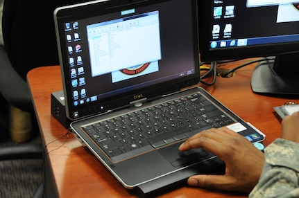 An Advanced Individual Training Soldier at Fort Rucker, Ala. conducts set up of an Army-issued notebook computer for his classwork June 18, 2013.  Cyber security should be practiced at work, home and the local coffee shop, experts say.