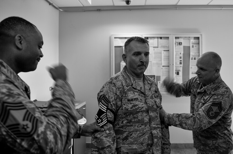 Senior Master Sgt. James McMurdy, 1st Special Operations Security Forces Squadron, has Chief Master Sgt. stripes pinned by members of the Chiefs Group at Hurlburt Field, Fla., Nov. 20, 2014. The Chiefs Group drove around Hurlburt to congratulate 15 chief selects. (U.S. Air Force photo/Senior Airman Christopher Callaway)
