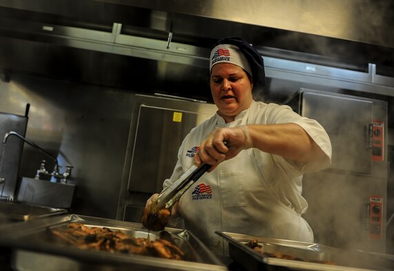 Deborah Baker, a 1st Special Operations Force Support Squadron food services cook, seasons chicken for lunch at the Reef Dining Facility on Hurlburt Field, Fla., Nov. 21, 2014. The Reef is one of two dining facilities at Hurlburt Field. (U.S. Air Force photo/Senior Airman Christopher Callaway)