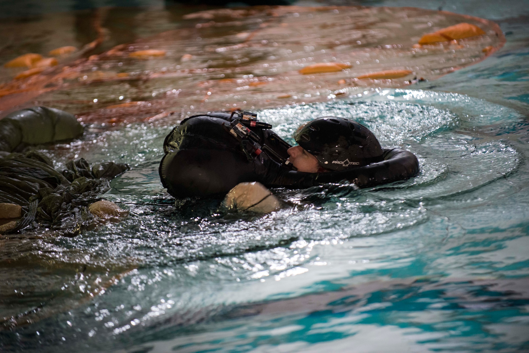 Staff Sgt. Anthony J. Barrette demonstrates the proper technique to get free of a parachute in the water during a survival course Nov. 4, 2014, at Minot Air Force Base, N.D. The course trains aviators on the proper techniques of survival if their aircraft goes down over water or enemy territory. Barrette is a 5th Operations Support Squadron operations and training NCO and survival, evasion, resistance, and escape instructor. (U.S. Air Force photo/Airman 1st Class Lauren Pitts) 