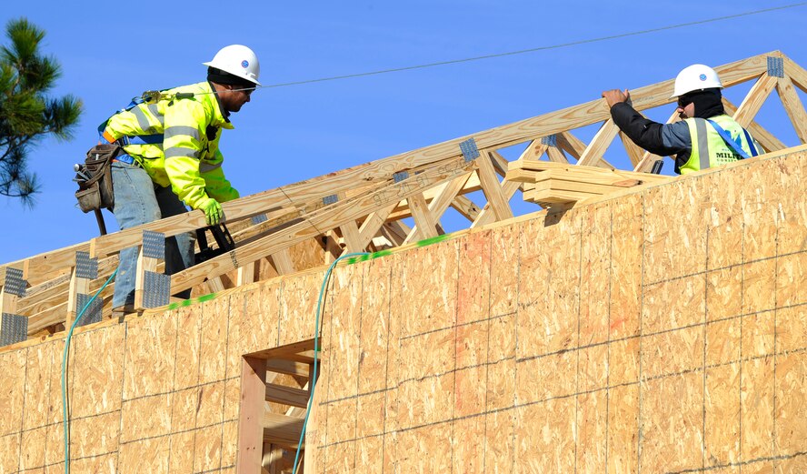 Two construction workers put up roof trusses at the Osprey Landing Neighborhood construction site on Hurlburt Field, Fla., Nov. 18, 2014. After framework is done, workers will start on the mechanicals, such as heating, ventilation, air conditioning and plumbing. (U.S. Air Force photo/Staff Sgt. Sarah Hanson)